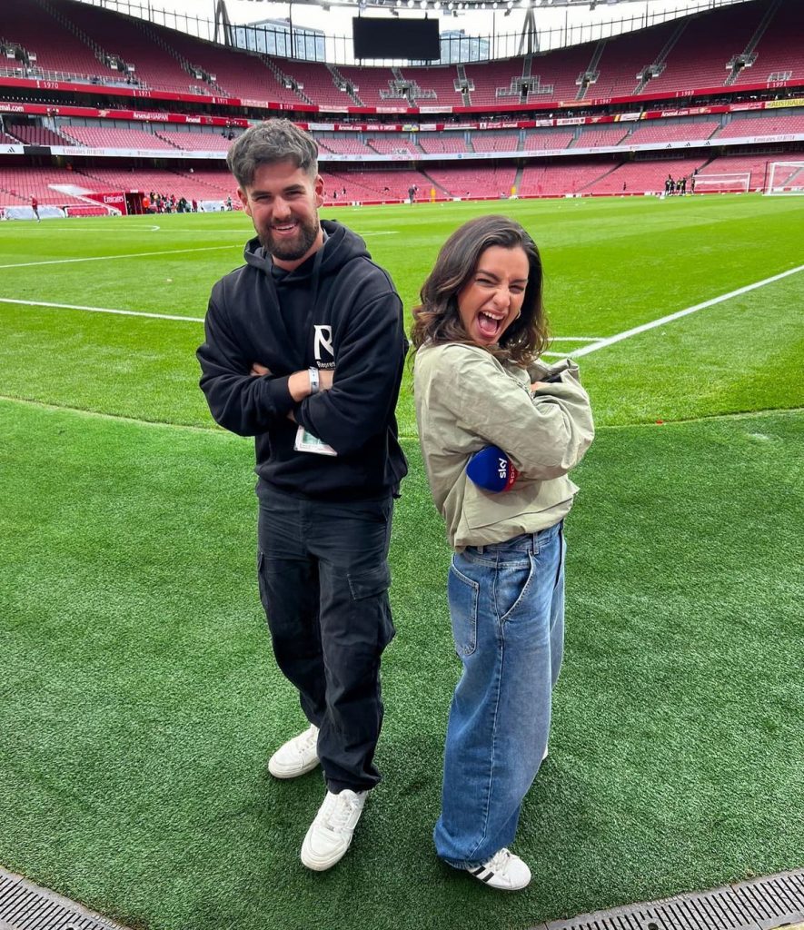 men and woman standing next to each other in football stadium