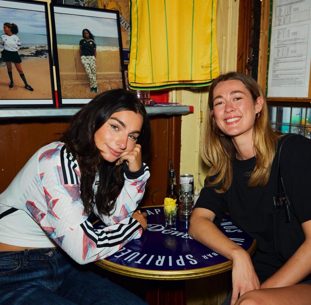 Two women sitting next to each other in a bar