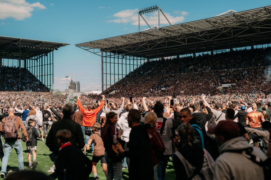 Football fans on St. Pauli football pitch.