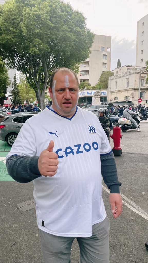 A football fan wearing a vintage Marseille jersey.