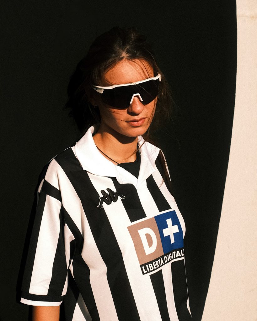 Women in sunglasses, wearing a vintage football jersey